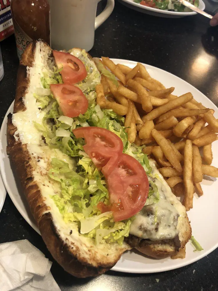A sandwich and fries on the table at a restaurant.