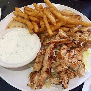 A plate of food with fries and sauce on it.